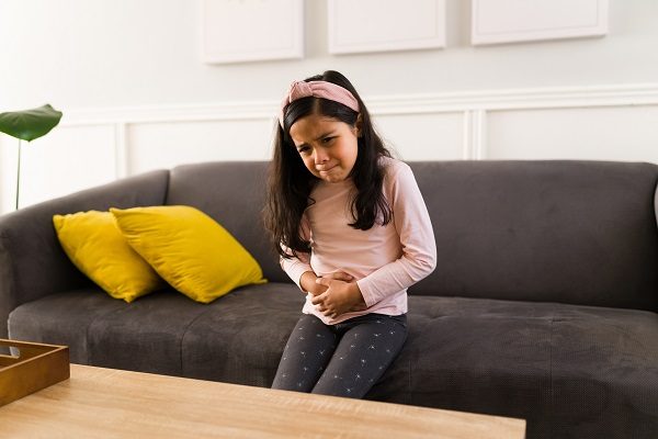 Young child holding stomach in pain